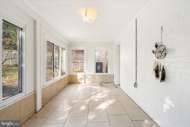 841 E Belvedere Ave E, Baltimore, MD 21212 - unfurnished sunroom featuring crown molding, tile patterned flooring, and brick wall