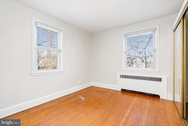 841 E Belvedere Ave E, Baltimore, MD 21212 - unfurnished bedroom featuring radiator heating unit, multiple windows, baseboards, and a closet