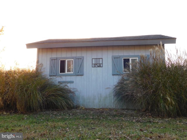 view of side of home featuring a shed