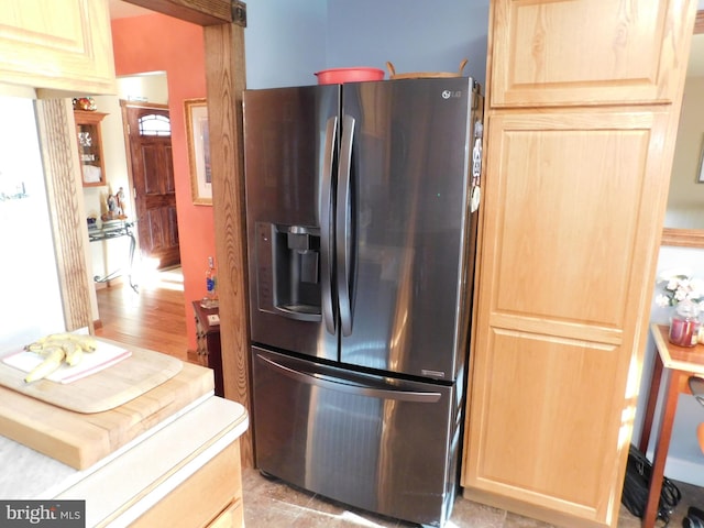 kitchen featuring light brown cabinets, light wood-type flooring, and stainless steel refrigerator with ice dispenser