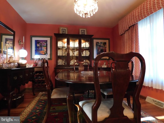 dining room with hardwood / wood-style floors and a chandelier