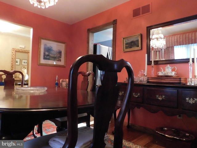 dining area featuring a notable chandelier and wood-type flooring