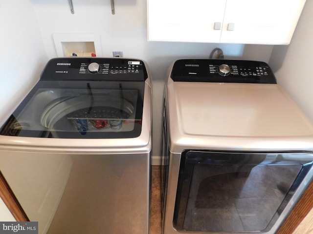 washroom featuring cabinets and washing machine and clothes dryer