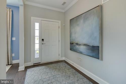 entryway featuring wood-type flooring and crown molding