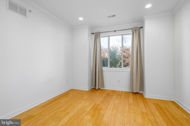 spare room featuring light hardwood / wood-style floors and crown molding