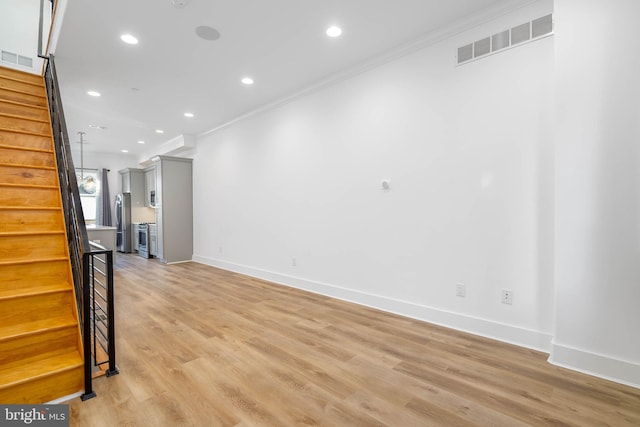 unfurnished living room with light hardwood / wood-style floors and ornamental molding