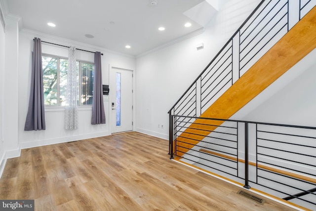 foyer featuring crown molding and light hardwood / wood-style flooring