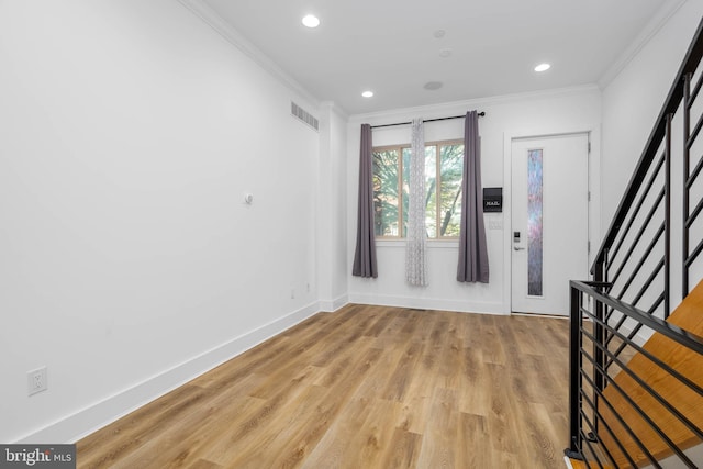 foyer with light hardwood / wood-style floors and ornamental molding