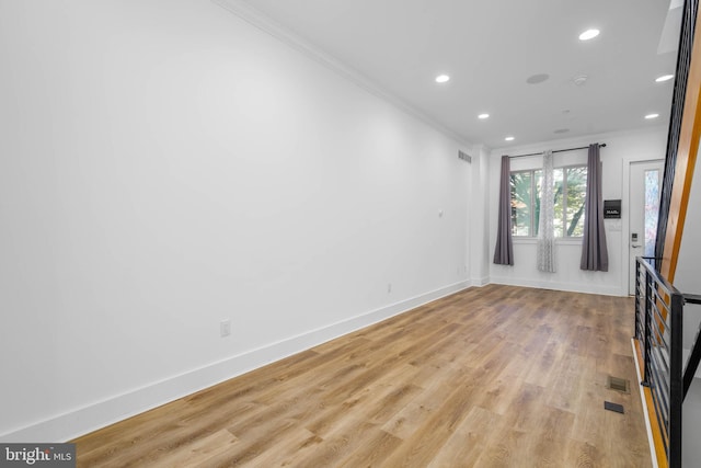 spare room featuring light hardwood / wood-style floors and crown molding