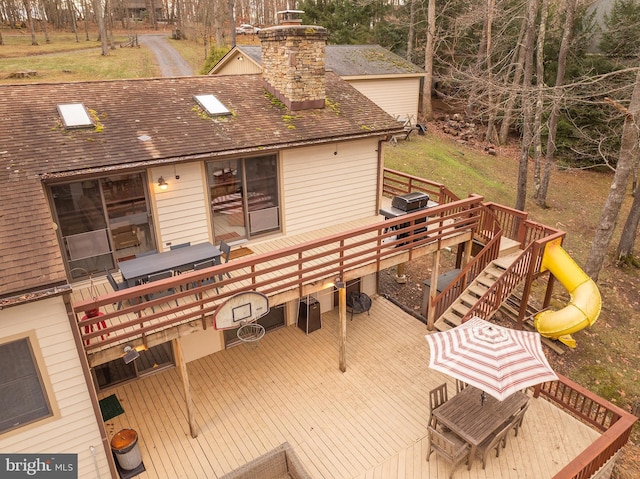 wooden terrace featuring a playground and a grill