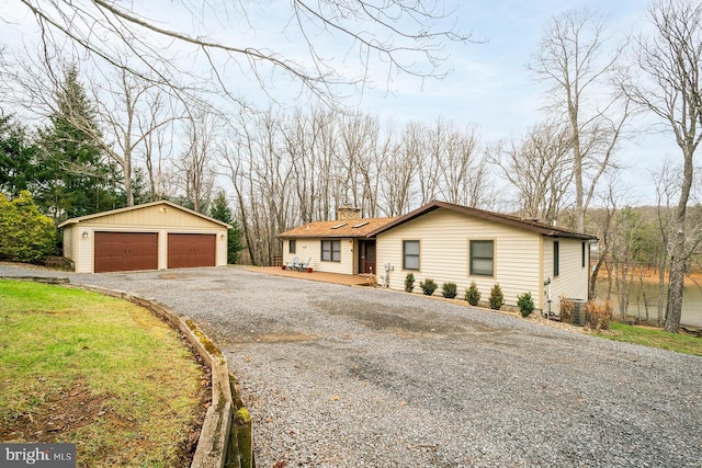 single story home featuring a garage and an outbuilding