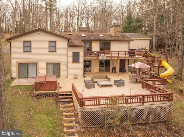 back of property featuring outdoor lounge area, a hot tub, and a wooden deck