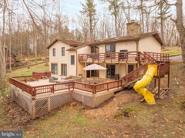 back of house with a wooden deck and an outdoor living space