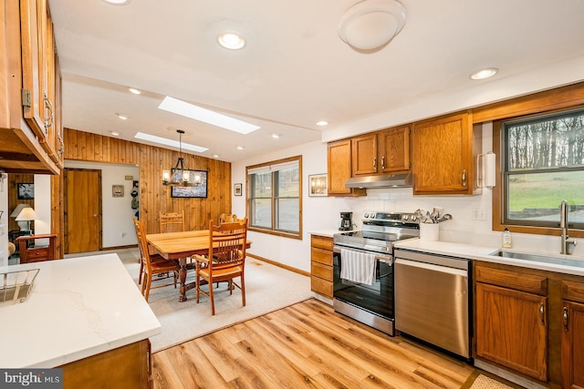 kitchen with decorative light fixtures, stainless steel appliances, a wealth of natural light, and sink