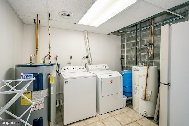 washroom with light tile patterned floors, electric water heater, and separate washer and dryer