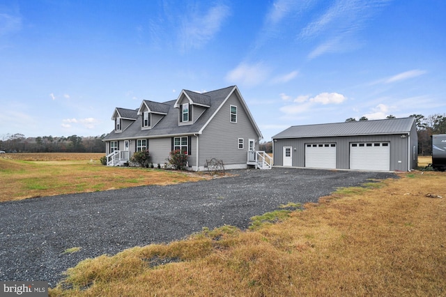 view of front of house with an outbuilding, a garage, and a front lawn