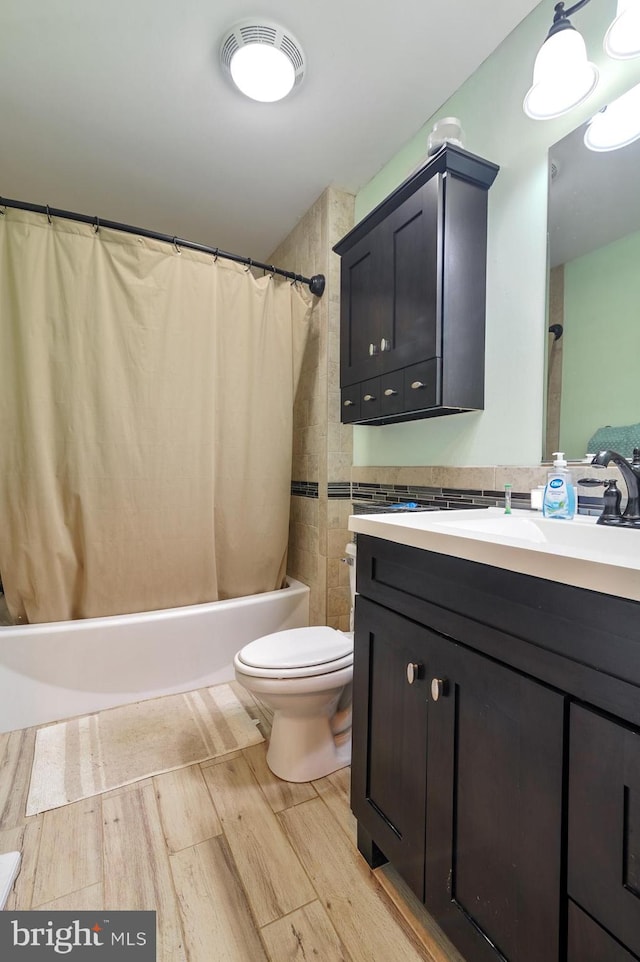 full bathroom featuring vanity, hardwood / wood-style flooring, toilet, and shower / tub combo with curtain