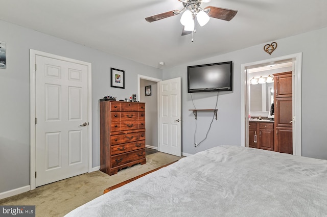 carpeted bedroom featuring vaulted ceiling, ensuite bath, ceiling fan, and sink