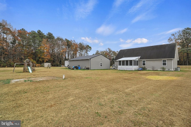 view of yard featuring a sunroom, cooling unit, and a playground