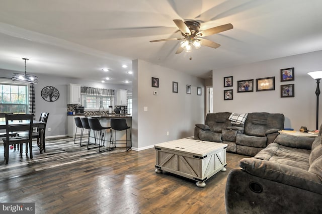 living room featuring ceiling fan, sink, and dark wood-type flooring