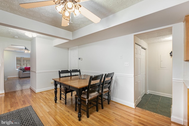 dining room with light hardwood / wood-style floors and a textured ceiling