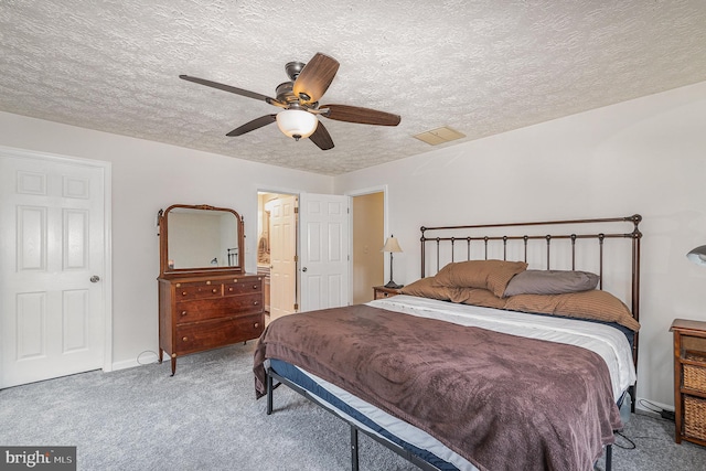 carpeted bedroom with ceiling fan, a textured ceiling, and connected bathroom