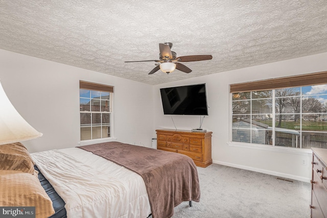 carpeted bedroom with a textured ceiling and ceiling fan