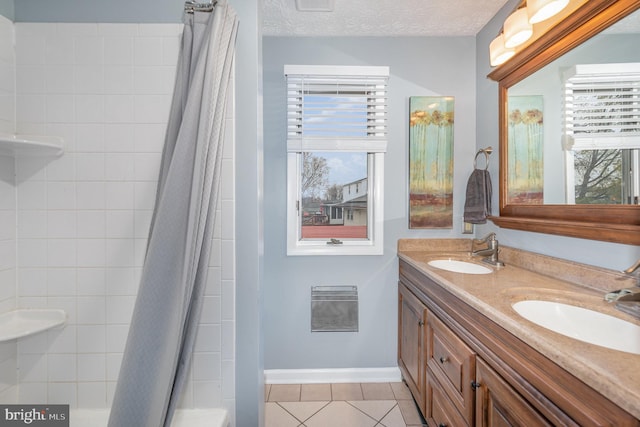 bathroom with a textured ceiling, vanity, tile patterned floors, and plenty of natural light