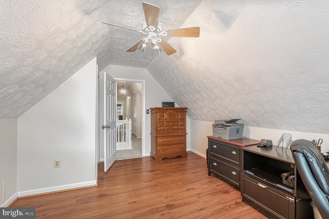 additional living space featuring a textured ceiling, ceiling fan, light hardwood / wood-style flooring, and vaulted ceiling