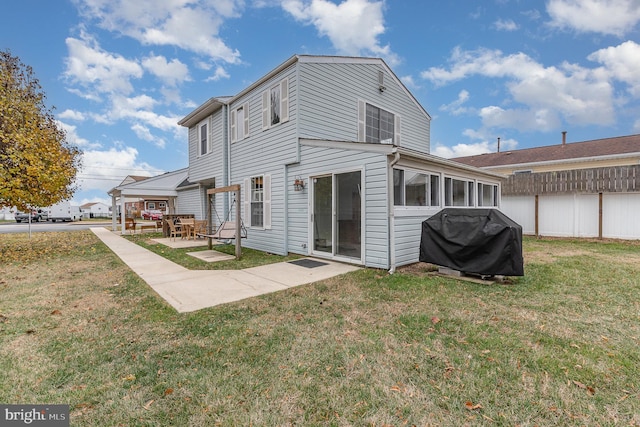 rear view of property with a patio and a lawn