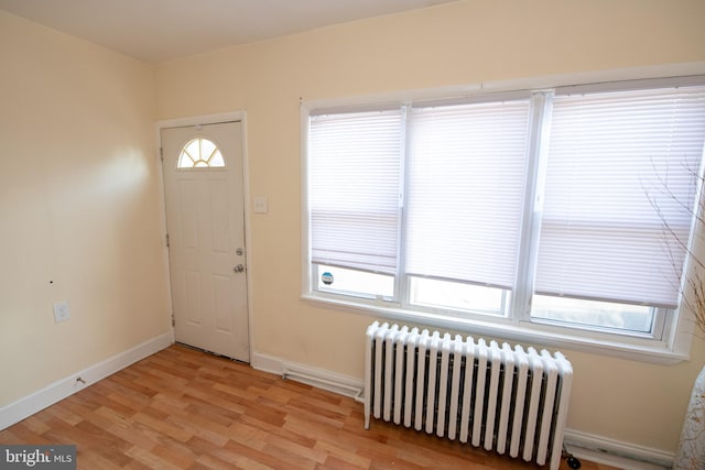 entryway with radiator heating unit and light wood-type flooring