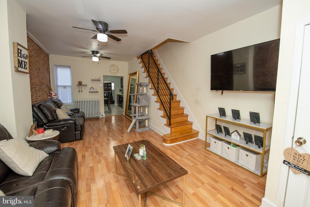 living room with hardwood / wood-style floors, radiator, and ceiling fan