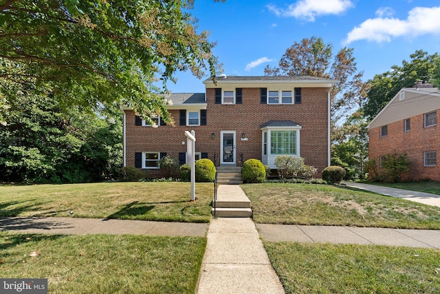 colonial inspired home featuring a front lawn