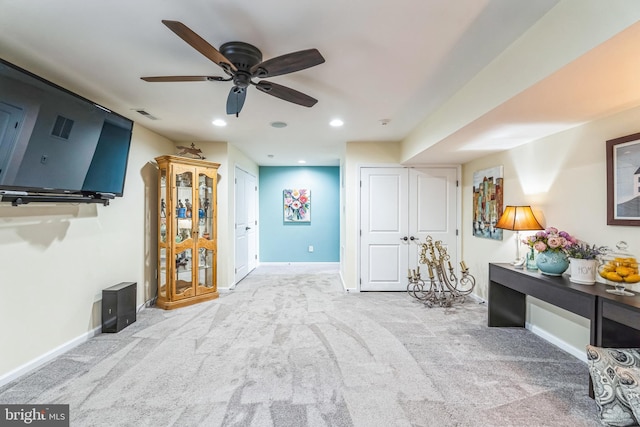 interior space featuring light colored carpet and ceiling fan