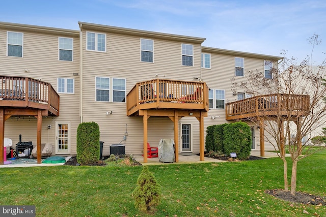 rear view of property featuring a lawn, a deck, and central AC