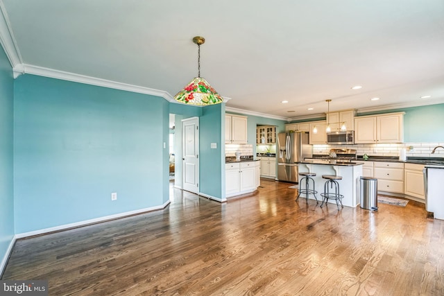 kitchen featuring stainless steel appliances, a kitchen island, hanging light fixtures, and light wood-type flooring