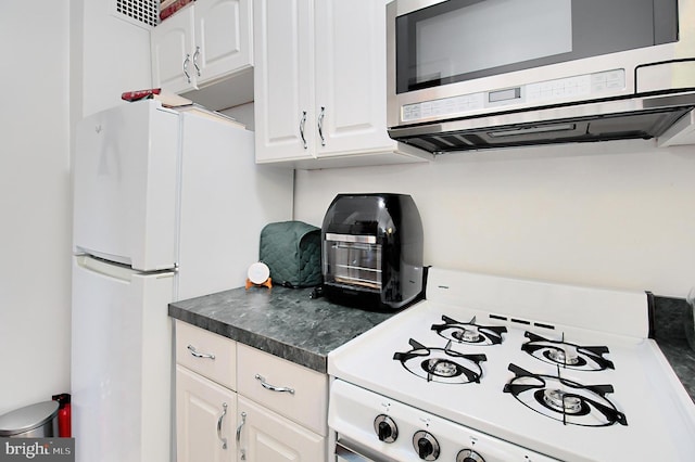 kitchen with white cabinetry and white appliances