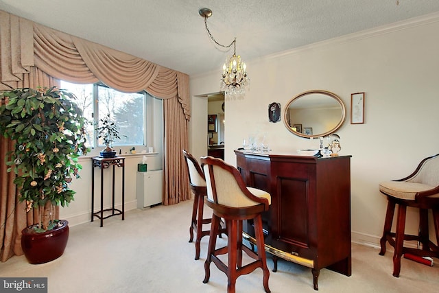 bar with a textured ceiling, a chandelier, light colored carpet, and ornamental molding