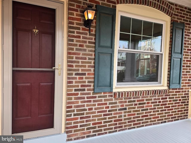 entrance to property featuring brick siding