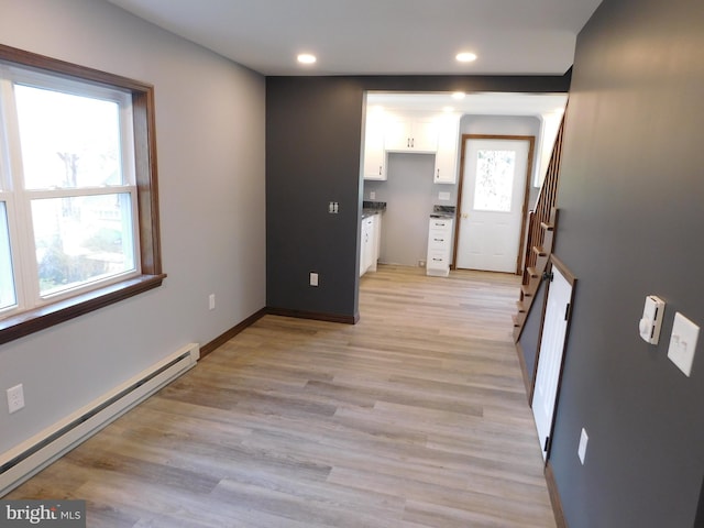 interior space with plenty of natural light, light wood-type flooring, and baseboard heating