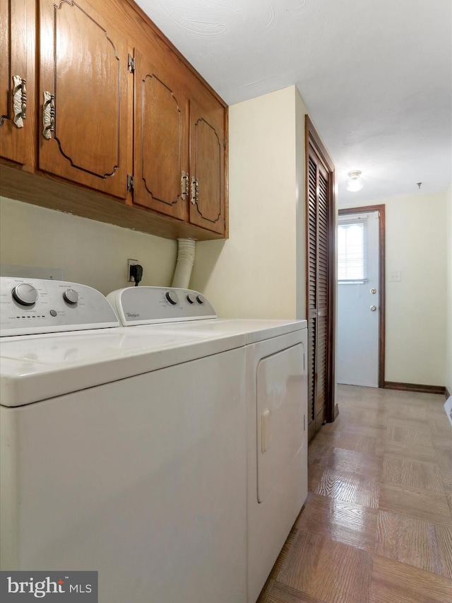 washroom with cabinets and washing machine and clothes dryer