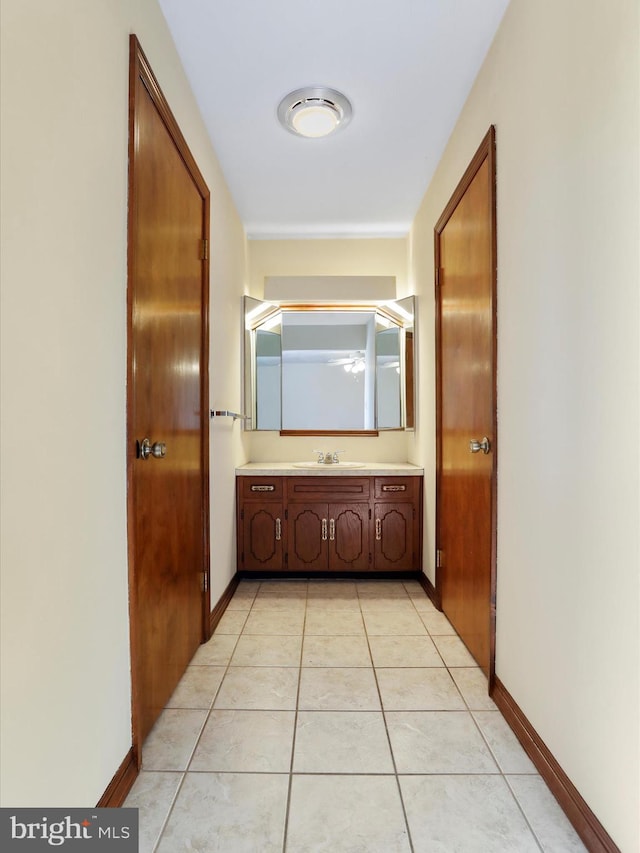 corridor with sink and light tile patterned flooring