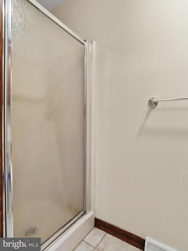 bathroom featuring tile patterned floors and a shower with shower door