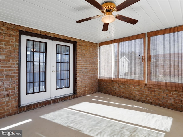 unfurnished sunroom featuring ceiling fan and french doors