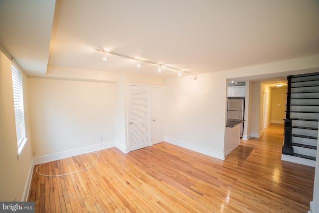 unfurnished room with wood-type flooring and track lighting