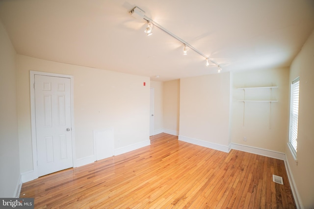 unfurnished room with light hardwood / wood-style floors and track lighting