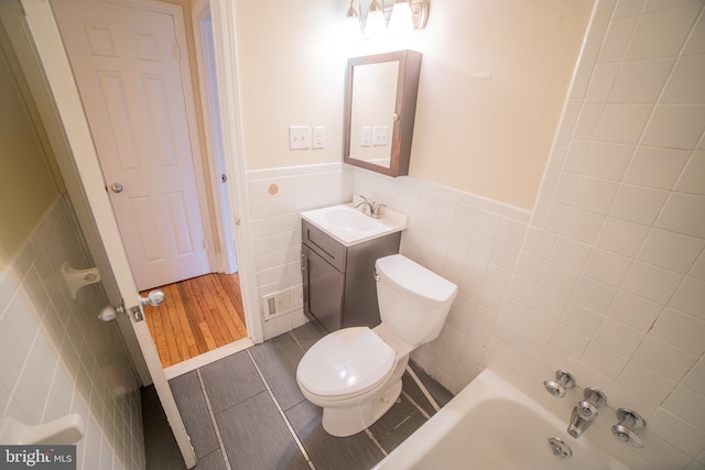 full bathroom featuring vanity, shower / washtub combination, hardwood / wood-style flooring, tile walls, and toilet