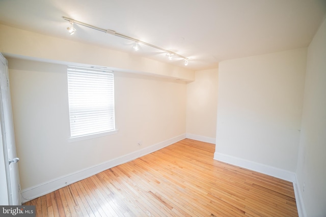 empty room featuring light wood-type flooring and track lighting