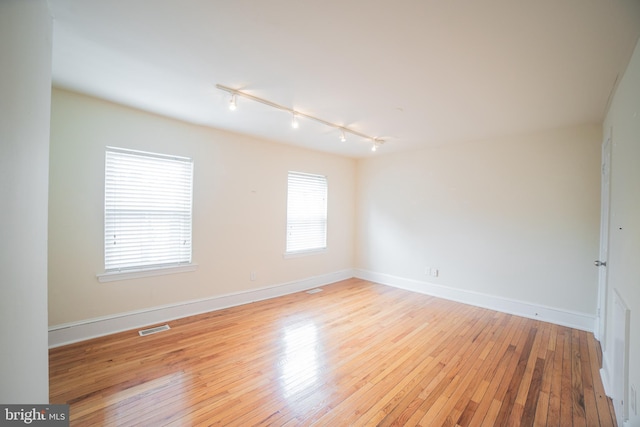 unfurnished room with rail lighting and light wood-type flooring