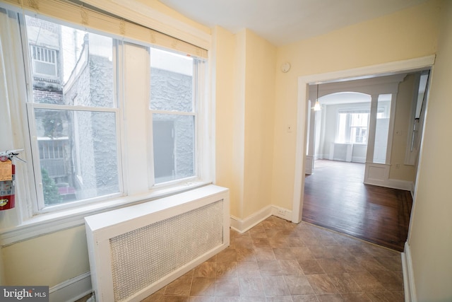 hallway with hardwood / wood-style floors and radiator heating unit